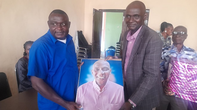 Colleagues present a portrait to Mr. Oyedipe